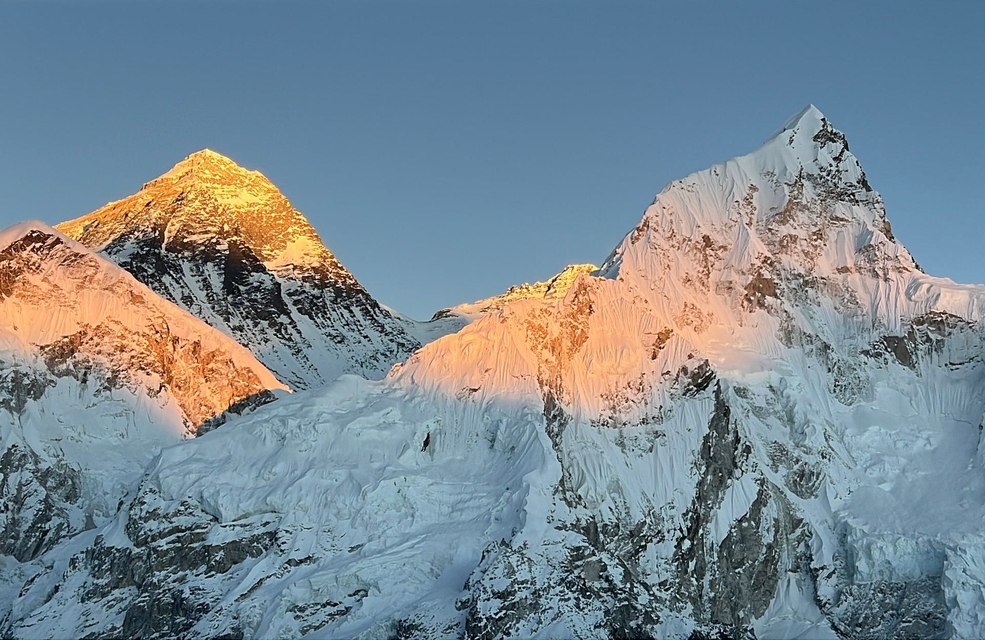 Sunset over Everest and Nuptse peaks from Everest Base Camp, golden light on snow and ice.