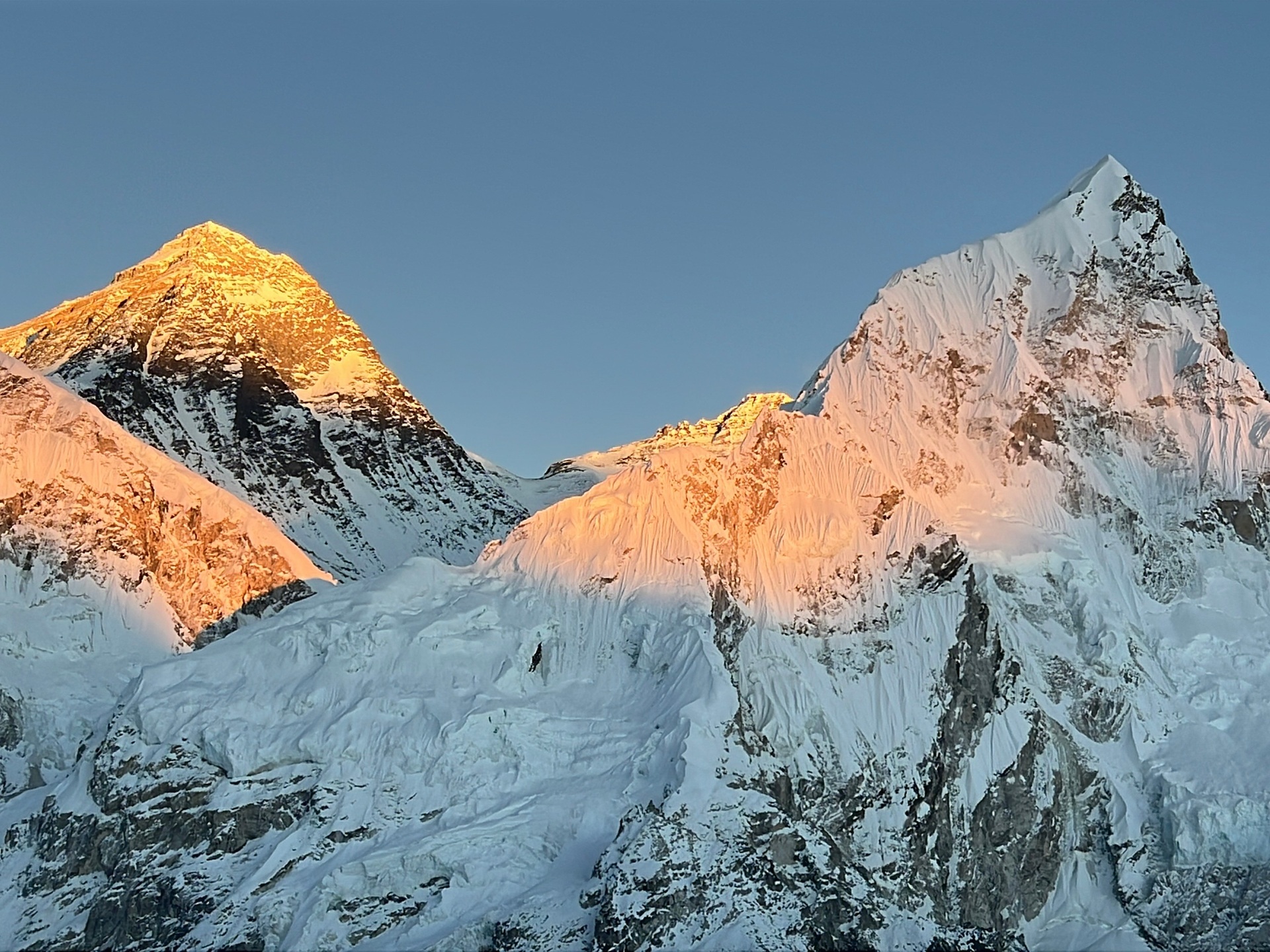 Sunset over Everest and Nuptse peaks from Everest Base Camp, golden light on snow and ice.