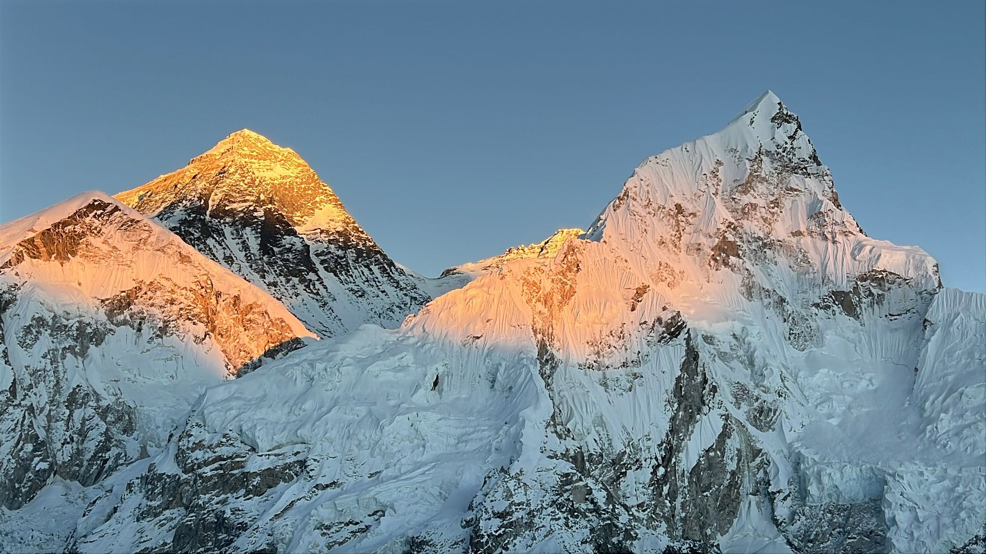 Sunset over Everest and Nuptse peaks from Everest Base Camp, golden light on snow and ice.